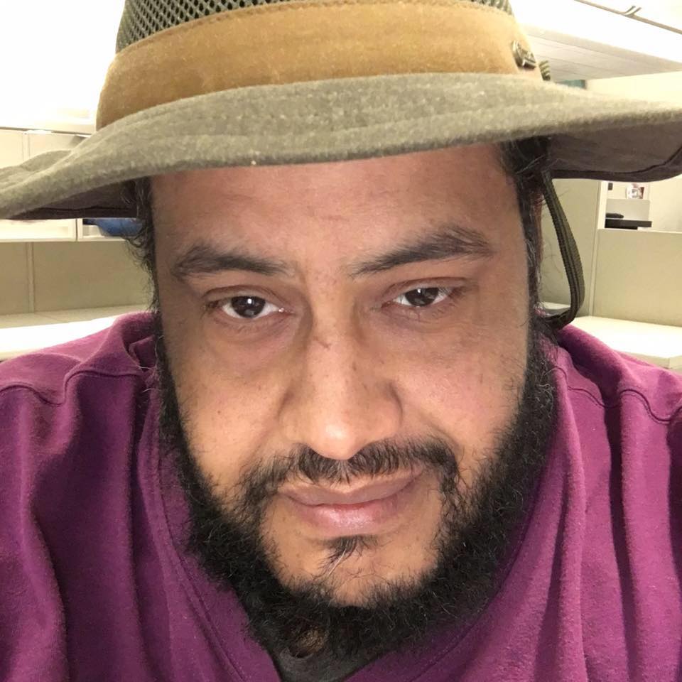 Sean Perkey as a grown man, wearing a straw hat and sporting a beard.