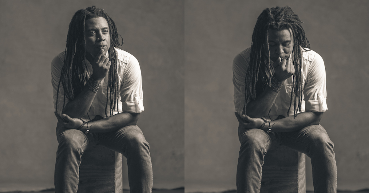 Brian Rogers in Black and White, contemplative, sitting on a block of wood, classic photography has studio background and lighting